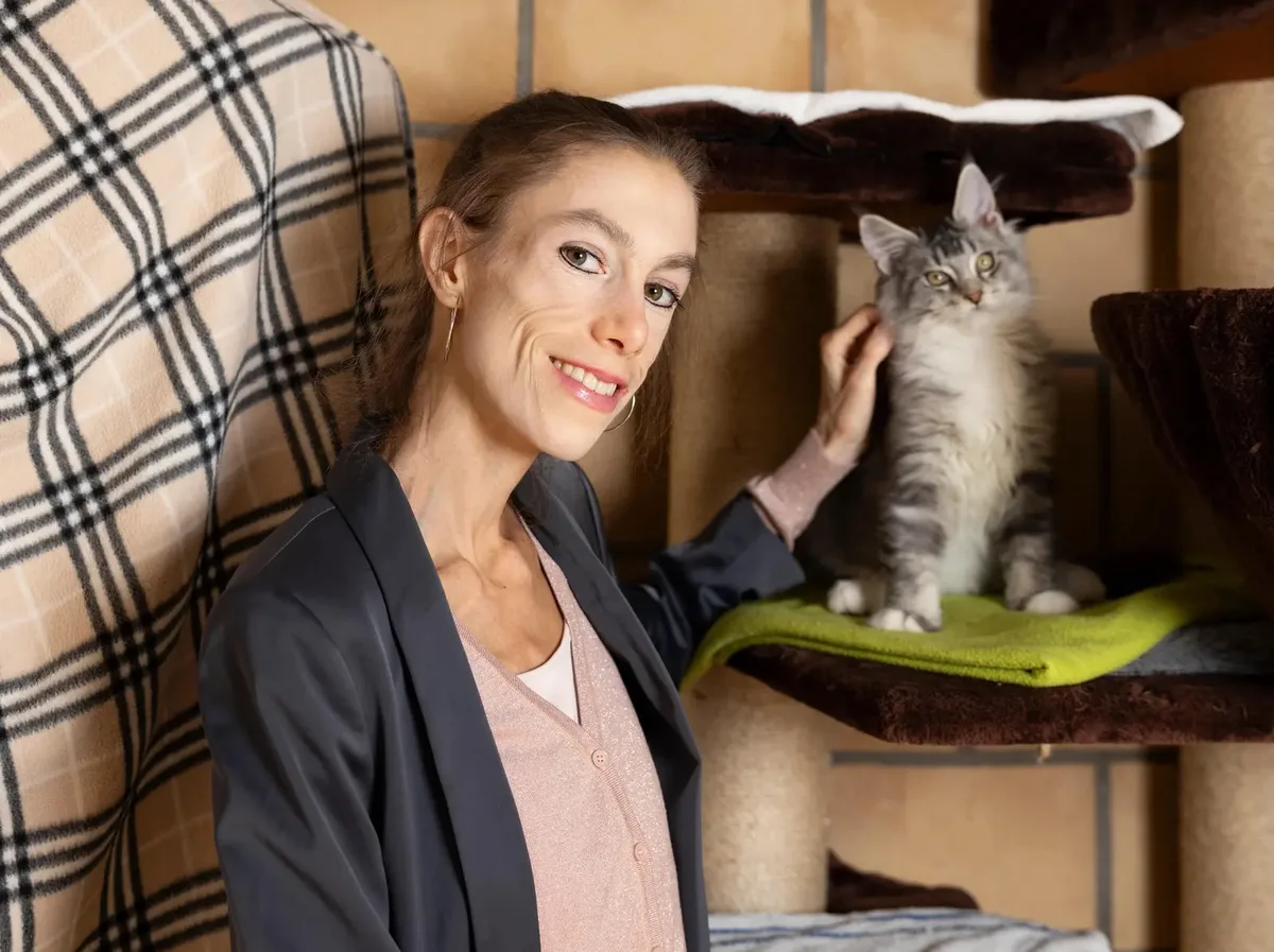 Man sieht Meret Schneider neben einer Katze.